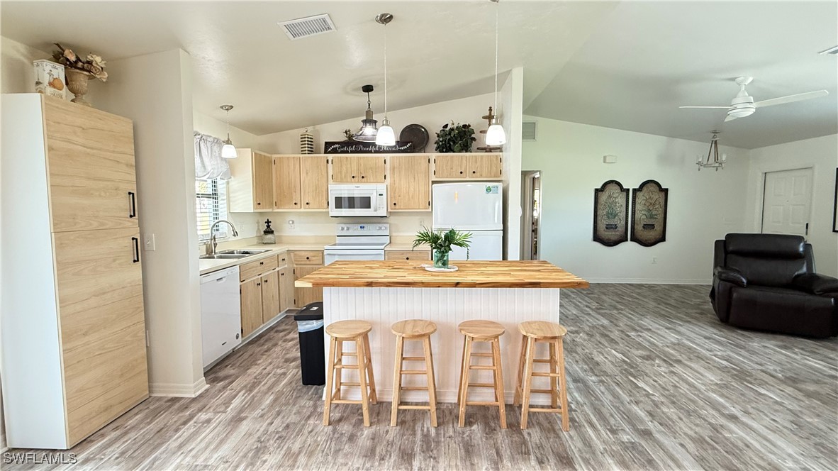 18161 Interlochen Lane Alva, FL 33920 - Photo 7 of 25 a kitchen with kitchen island a stove a refrigerator and a dining table with wooden floor