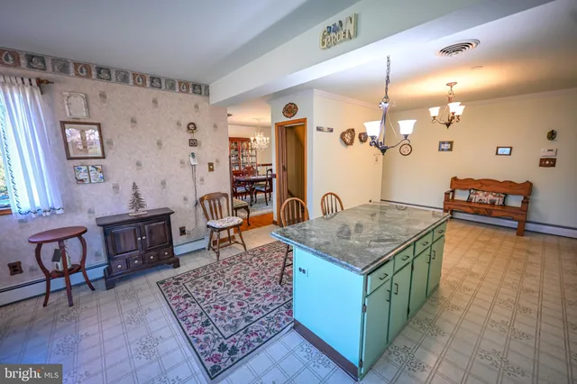 a living room with granite countertop furniture a rug kitchen view and a table