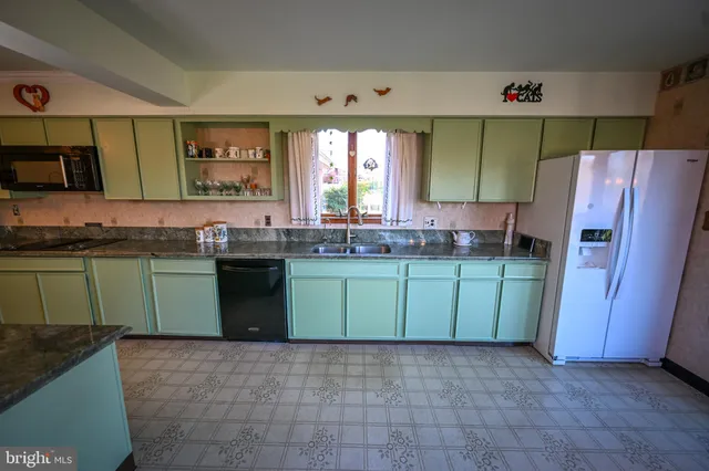 a kitchen with green cabinets and a sink