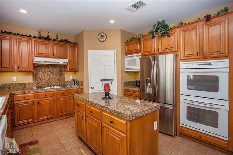 14396 Peach Hill Road Moorpark, CA 93021 - Photo 15 of 45 a kitchen with granite countertop stainless steel appliances a stove top oven and refrigerator