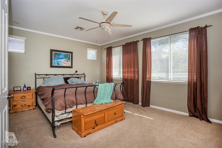 14396 Peach Hill Road Moorpark, CA 93021 - Photo 24 of 45 a spacious bedroom with a bed and a chandelier