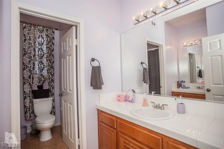 14396 Peach Hill Road Moorpark, CA 93021 - Photo 30 of 45 a bathroom with a granite countertop sink toilet and shower