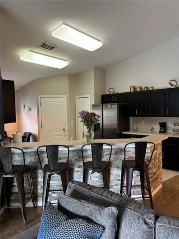 a living room with furniture a flat screen tv and kitchen view