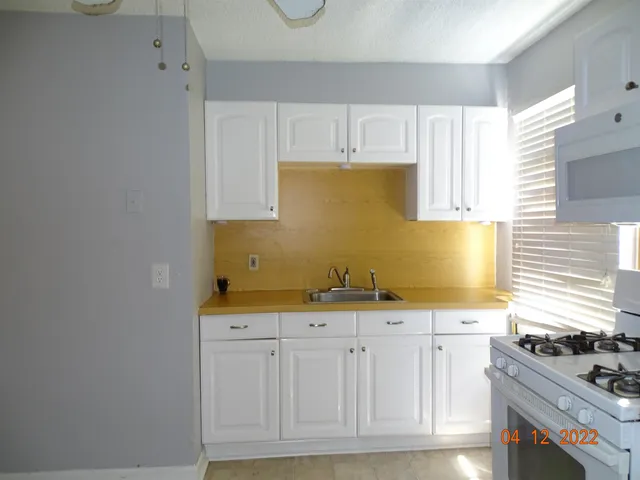 a kitchen with granite countertop a sink and a stove