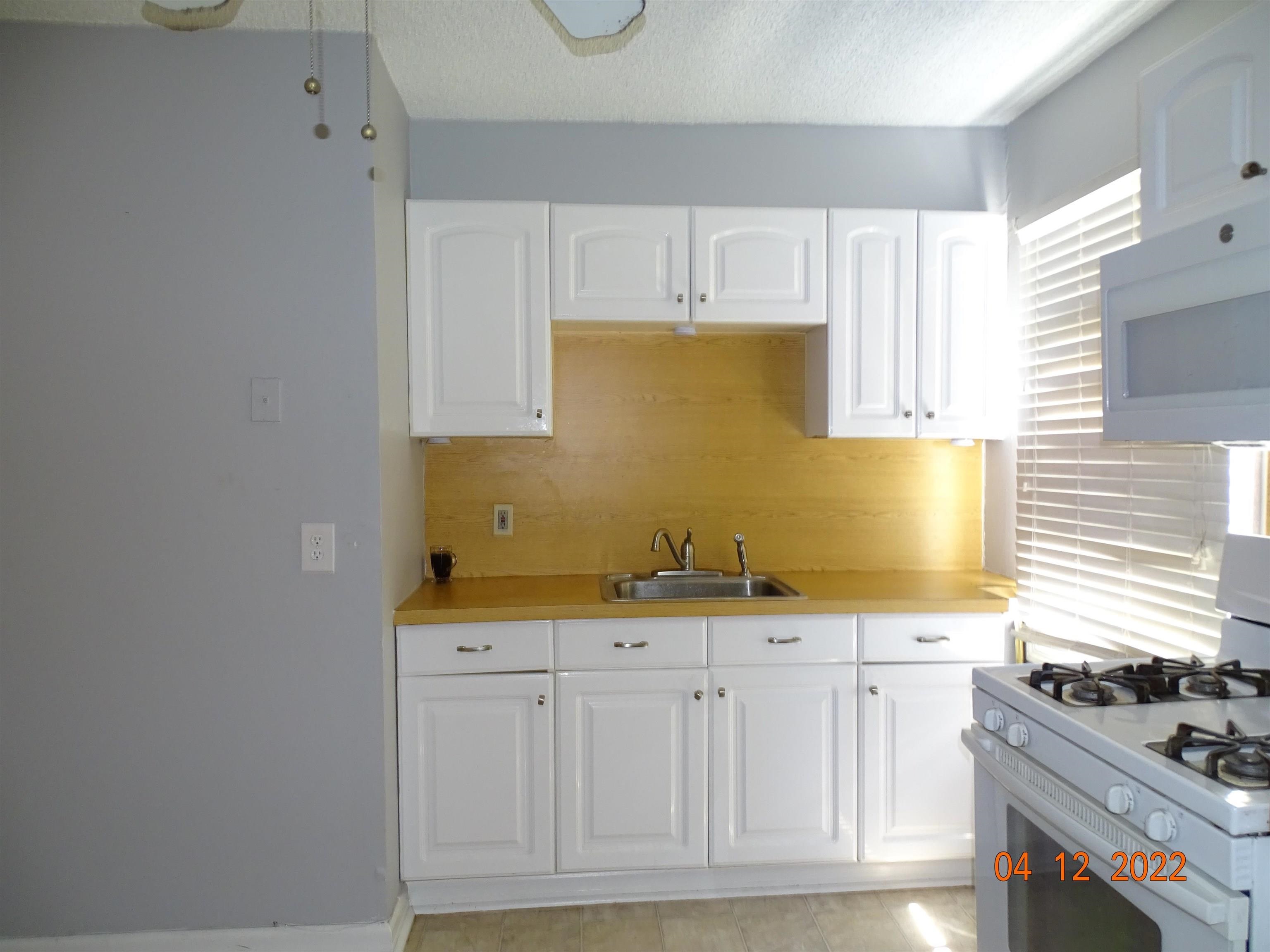 124 West 8th Street, Unit 2 Bayonne, NJ 07002 - Photo 17 of 19 a kitchen with granite countertop a sink and a stove