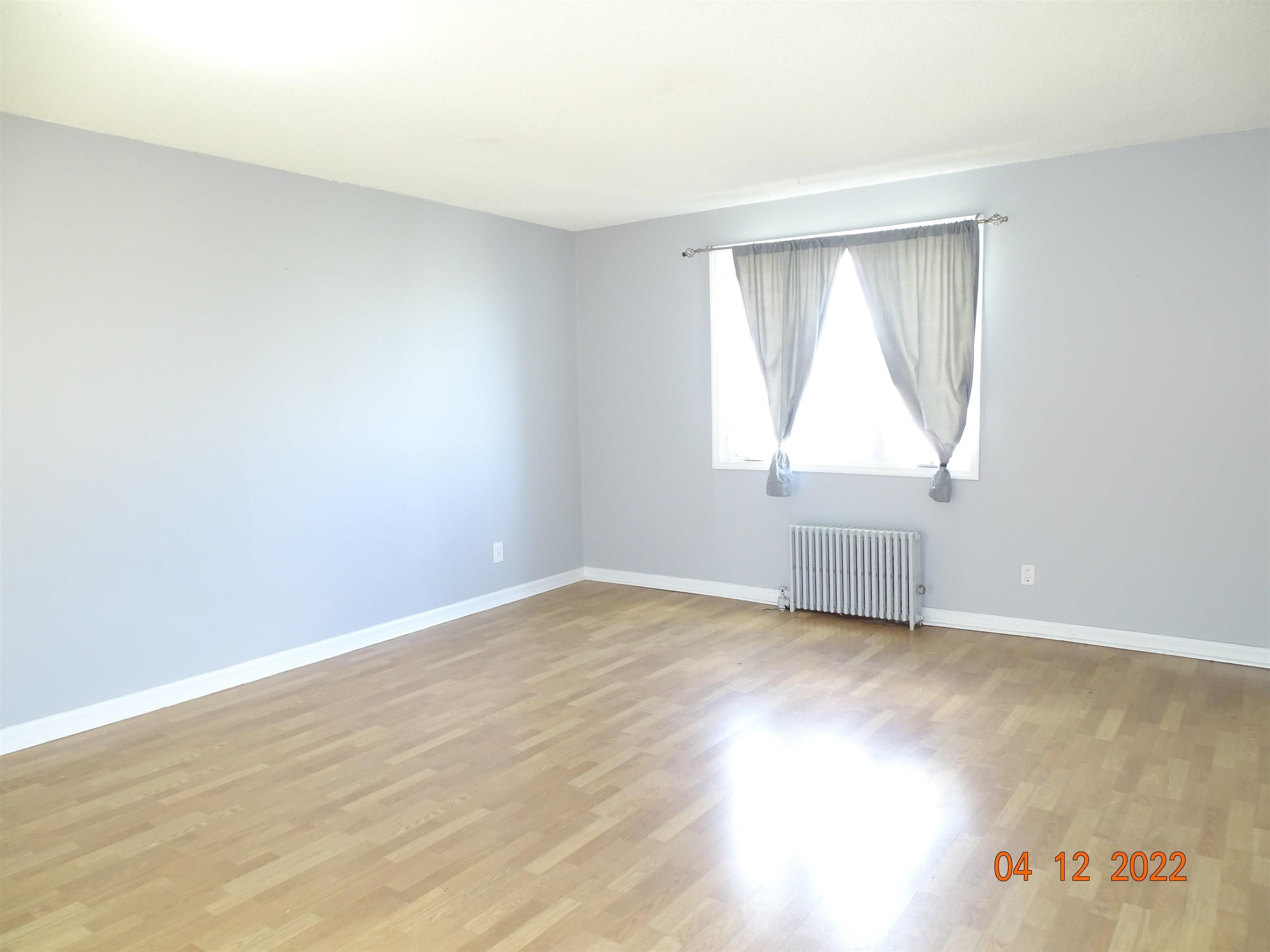 124 West 8th Street, Unit 2 Bayonne, NJ 07002 - Photo 7 of 19 an empty room with wooden floor and windows