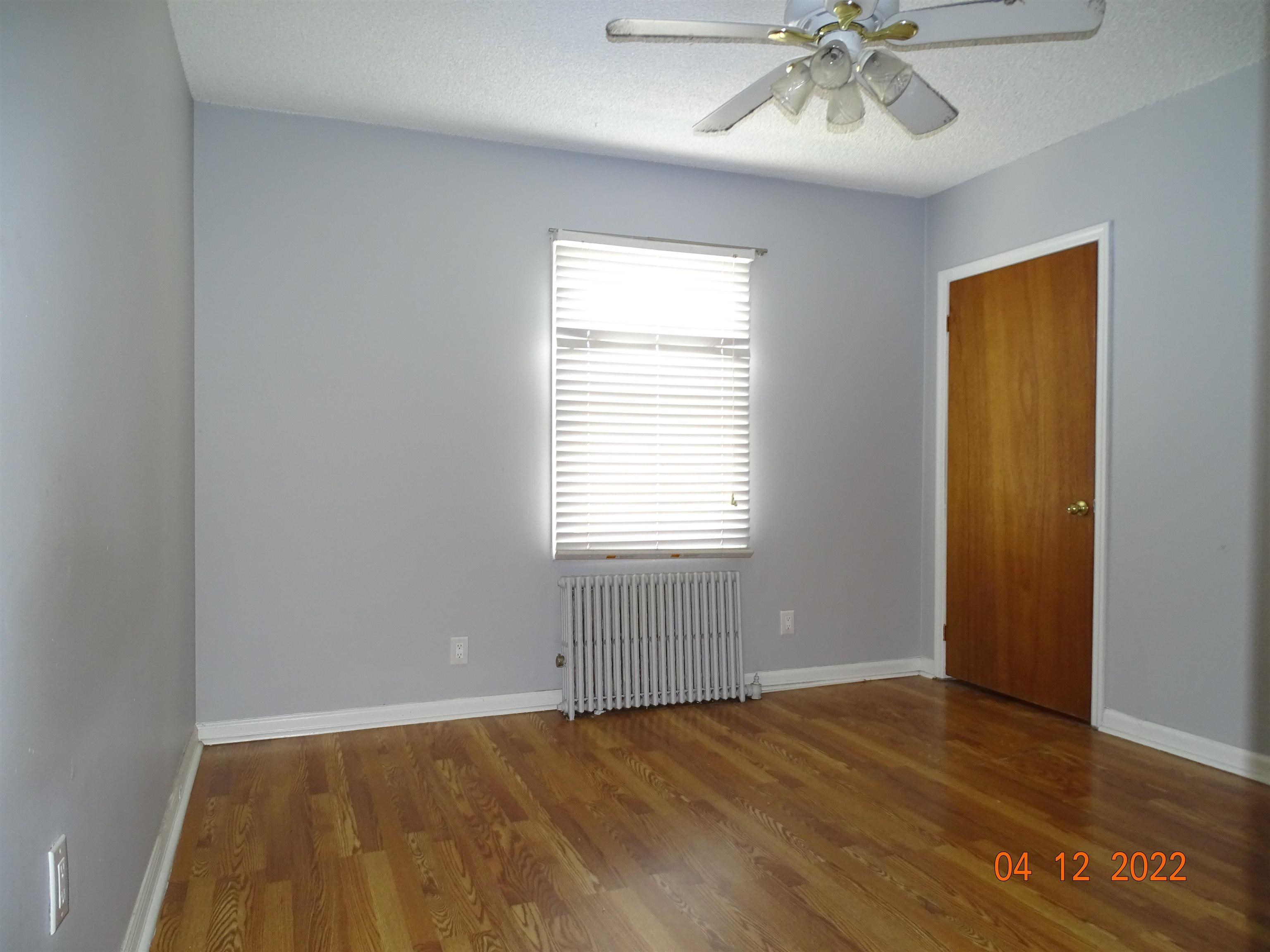 124 West 8th Street, Unit 2 Bayonne, NJ 07002 - Photo 10 of 19 a view of an empty room with wooden floor and a window
