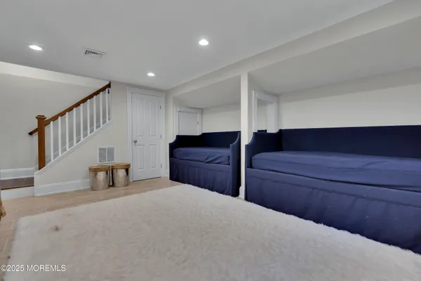 a bedroom with a bed chair and wooden floor