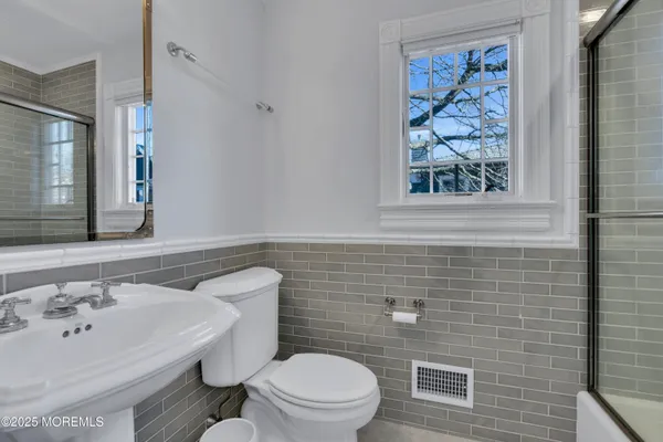 a bathroom with a granite countertop sink mirror and a bathtub