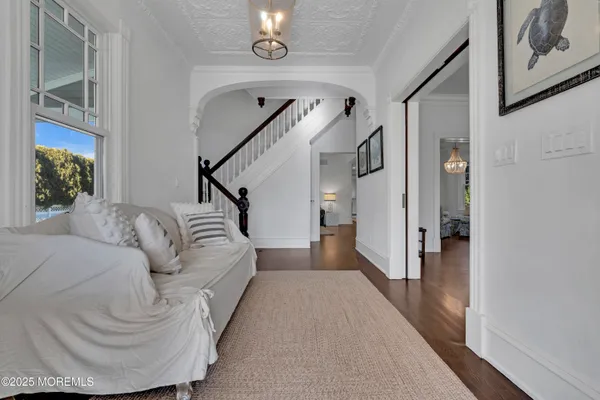 a living room with furniture a dining table and a chandelier