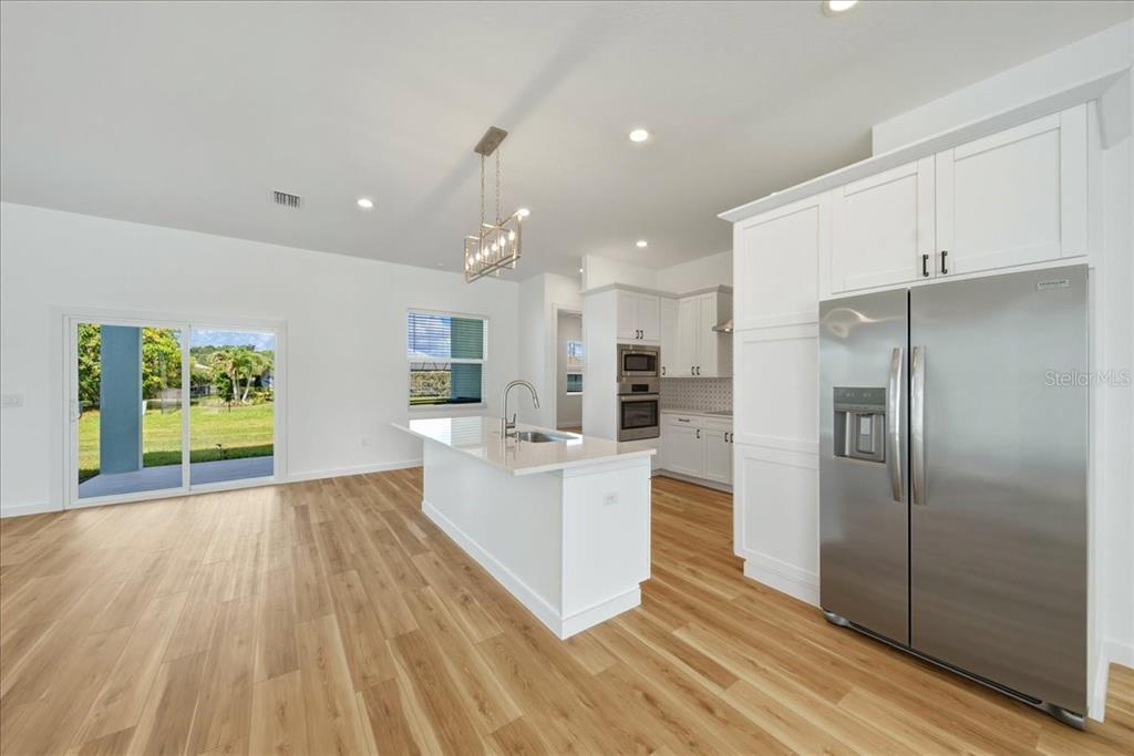 1215 Rio De Janeiro Avenue Punta Gorda, FL 33983 - Photo 35 of 65 a large kitchen with a lot of white cabinets a sink stainless steel appliances and cabinets
