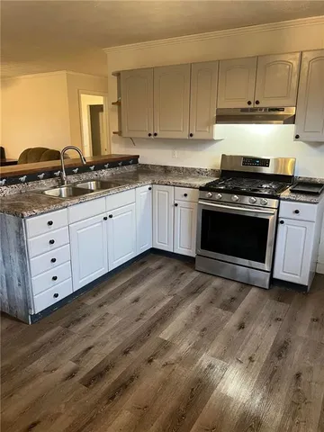 a kitchen with granite countertop a stove and a sink