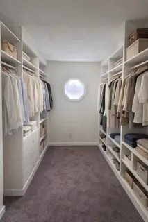 a view of walk in closet with clothes and shoes