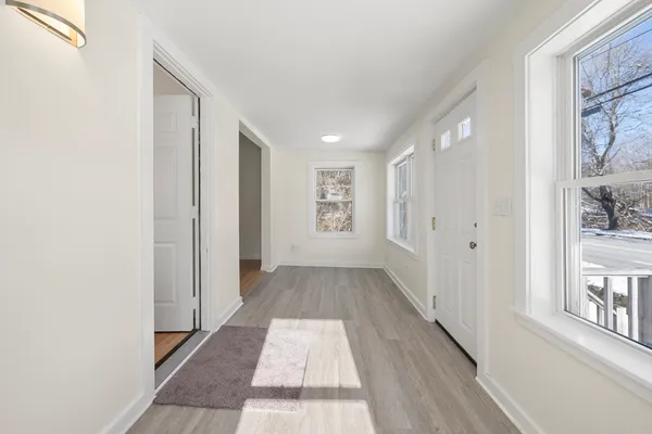 a view of a hallway with wooden floor and windows