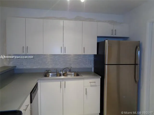 a kitchen with a refrigerator and cabinets