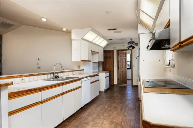 a large kitchen with stainless steel appliances granite countertop a lot of counter space and wooden floor