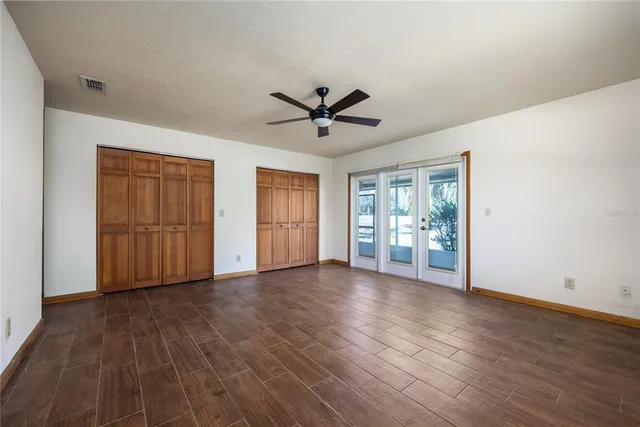 a view of n empty room with window and wooden floor