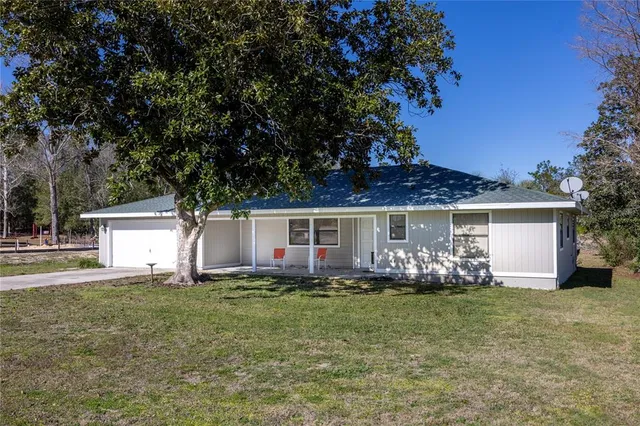 a front view of house with yard and trees in the background