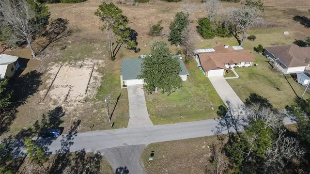 an aerial view of a house with a yard and mountain