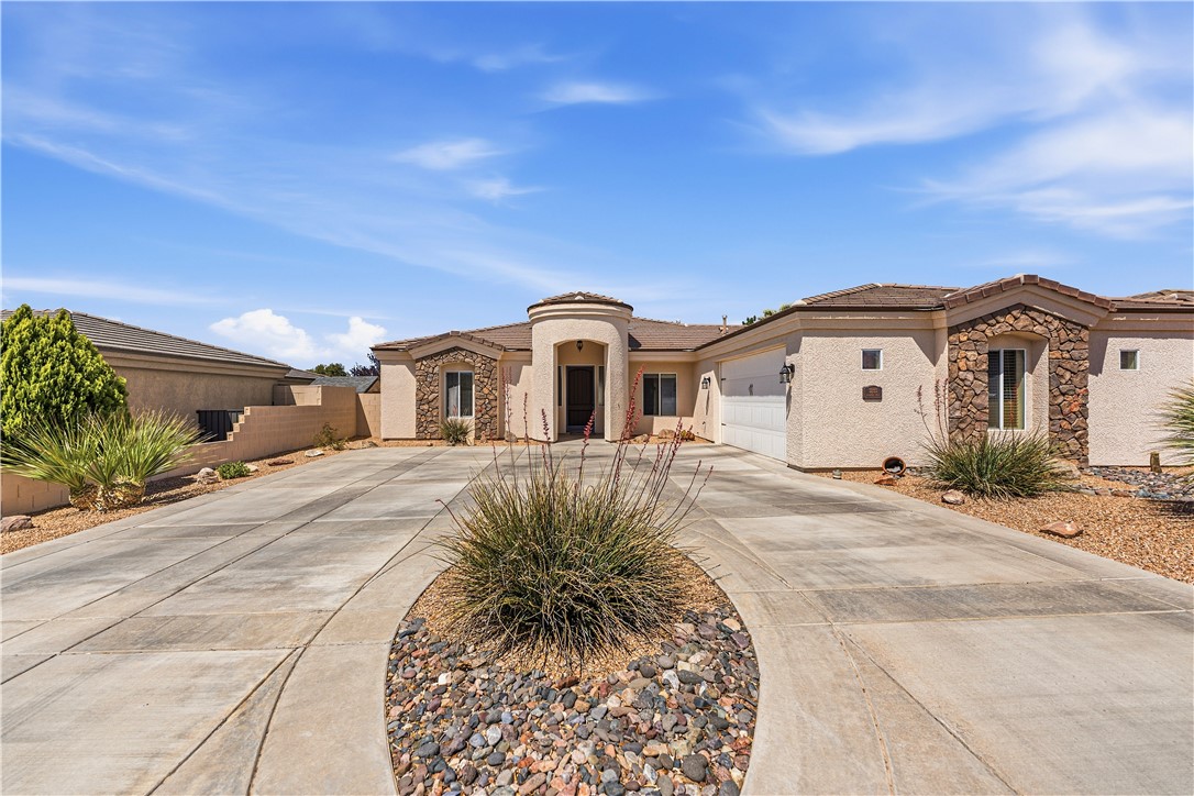 3315 Rainbow Mine Road Kingman, AZ 86401 - Photo 53 of 54 The property features a stucco exterior with stone accents, a paved driveway, and a well-maintained desert landscape