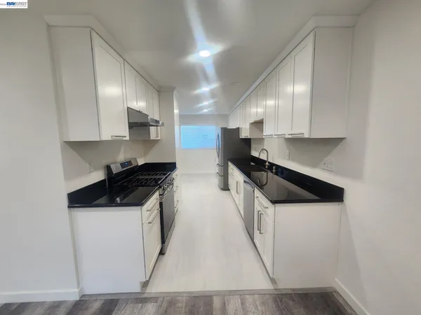 a kitchen with stainless steel appliances granite countertop a sink stove and cabinets