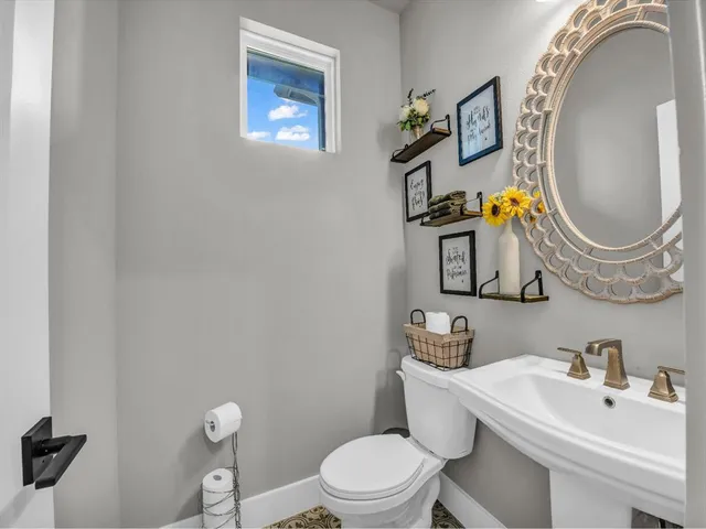 a bathroom with a toilet sink and mirror