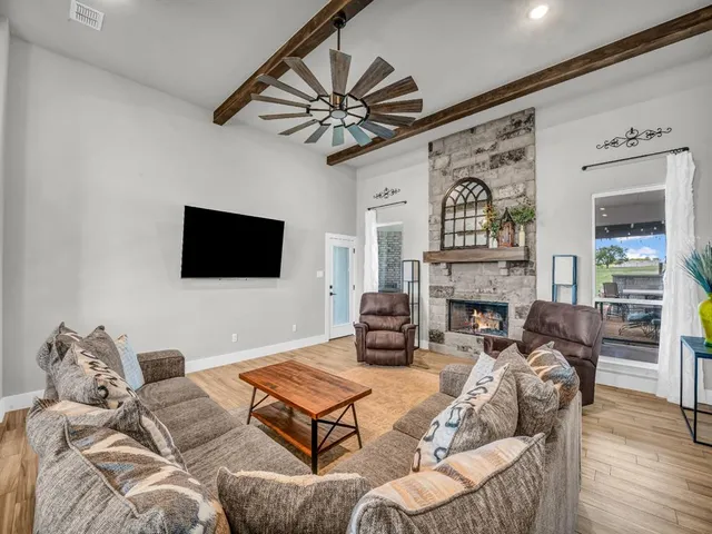a living room with furniture a flat screen tv and a fireplace