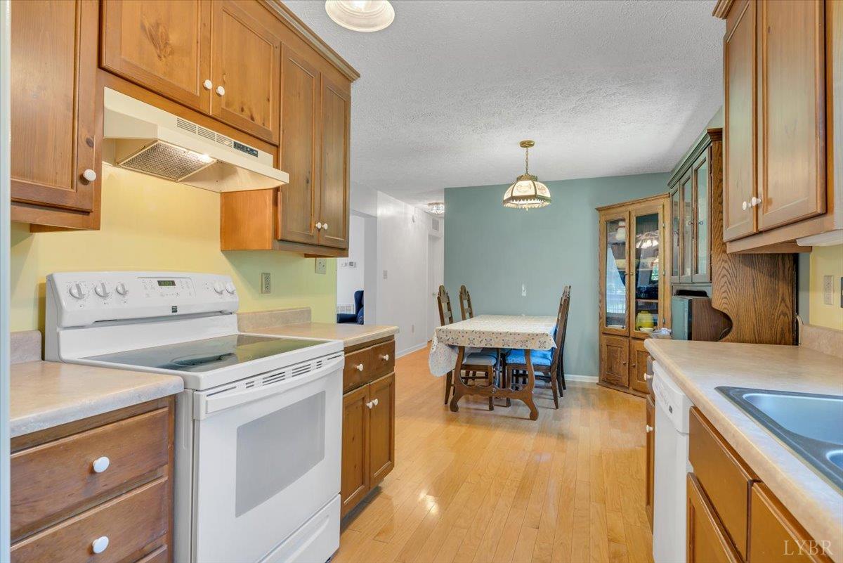 1124 Homeplace Road Bedford, VA 24523 - Photo 15 of 47 a kitchen with a stove a sink a dining table and chairs