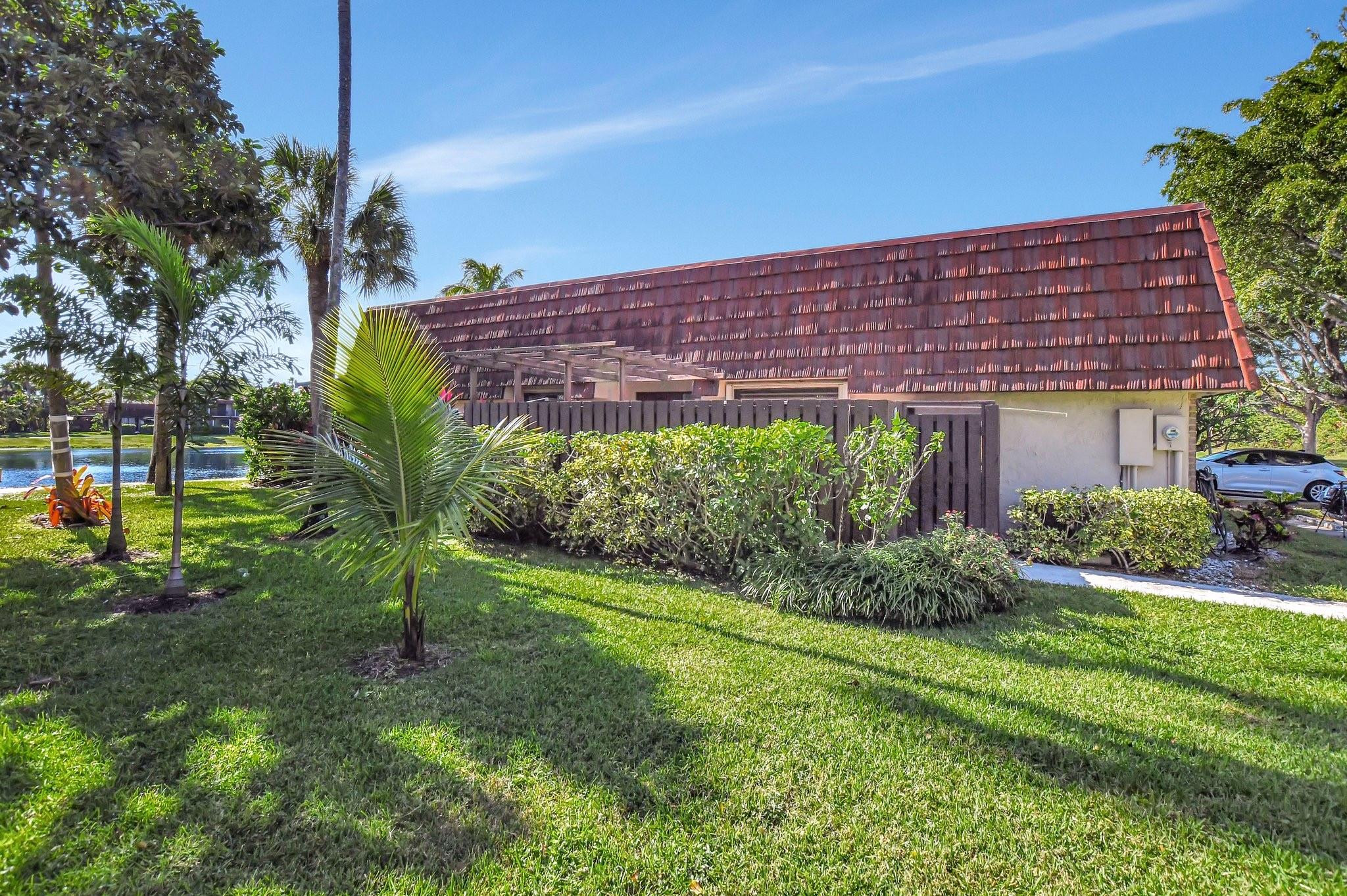 8073 Boca Rio Drive Boca Raton, FL 33433 - Photo 39 of 56 a view of a backyard with plants and a lawn chairs