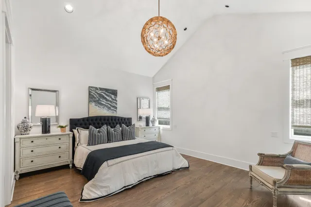 a bedroom with a bed and a lamp on dresser