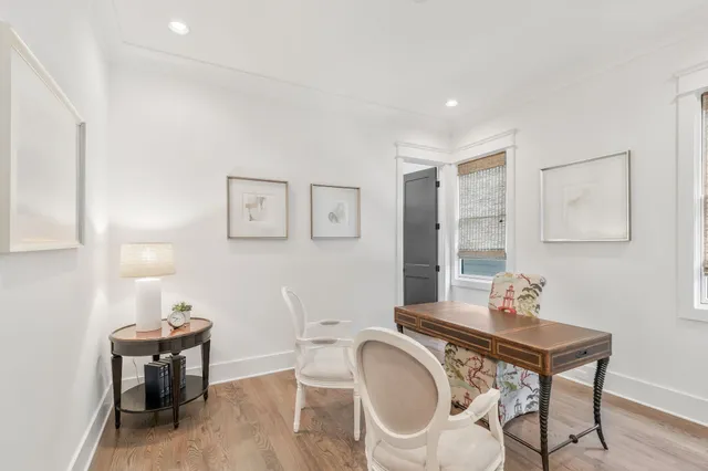 a view of a hallway with wooden floor and a bathroom