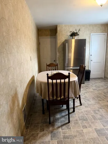 a bedroom with a bed and a refrigerator