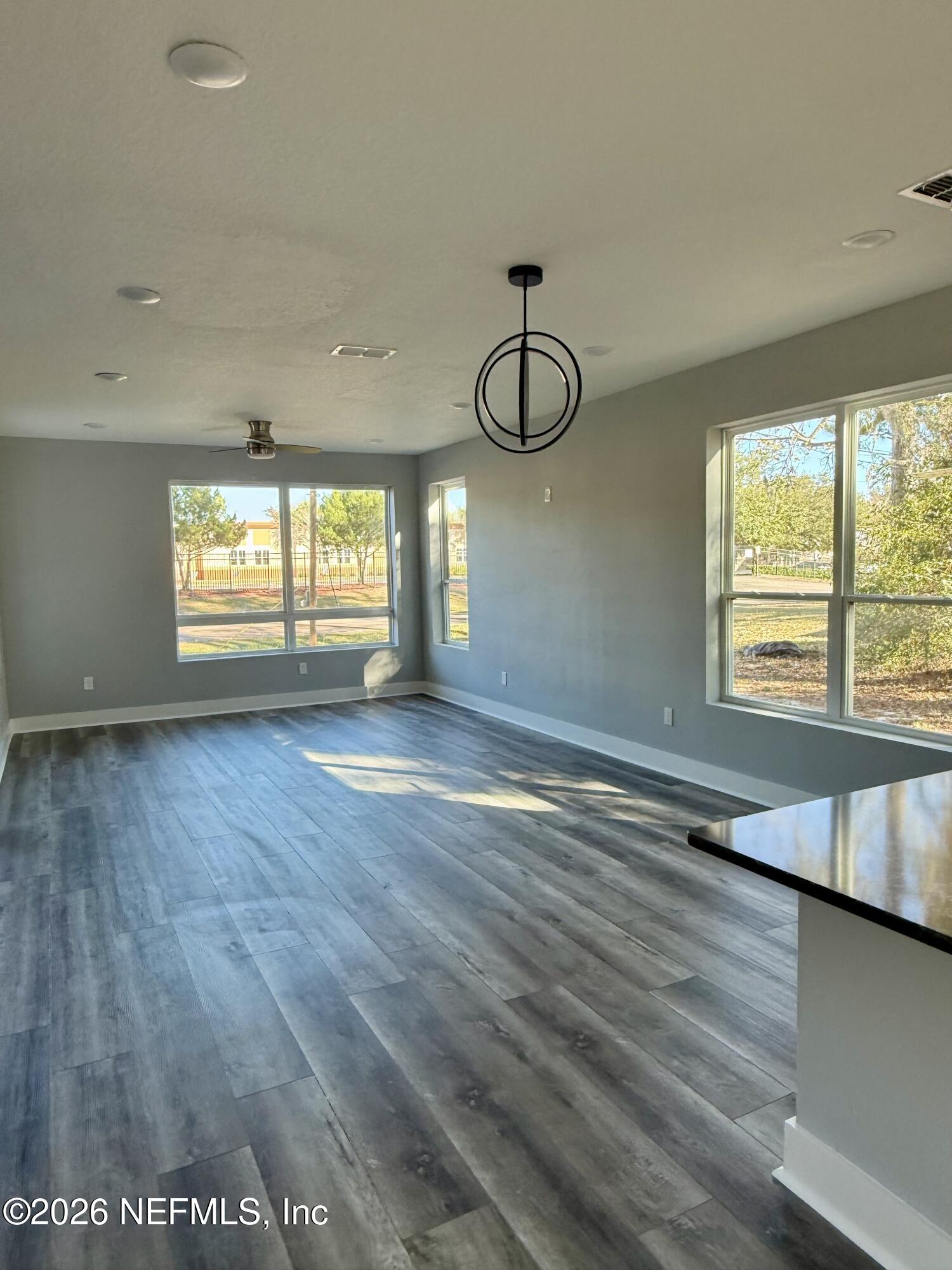 6056 Bagley Road Jacksonville, FL 32209 - Photo 3 of 32 a view of an empty room with window and wooden floor