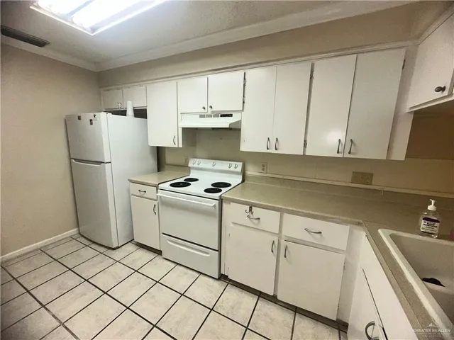 a kitchen with a refrigerator sink and cabinets
