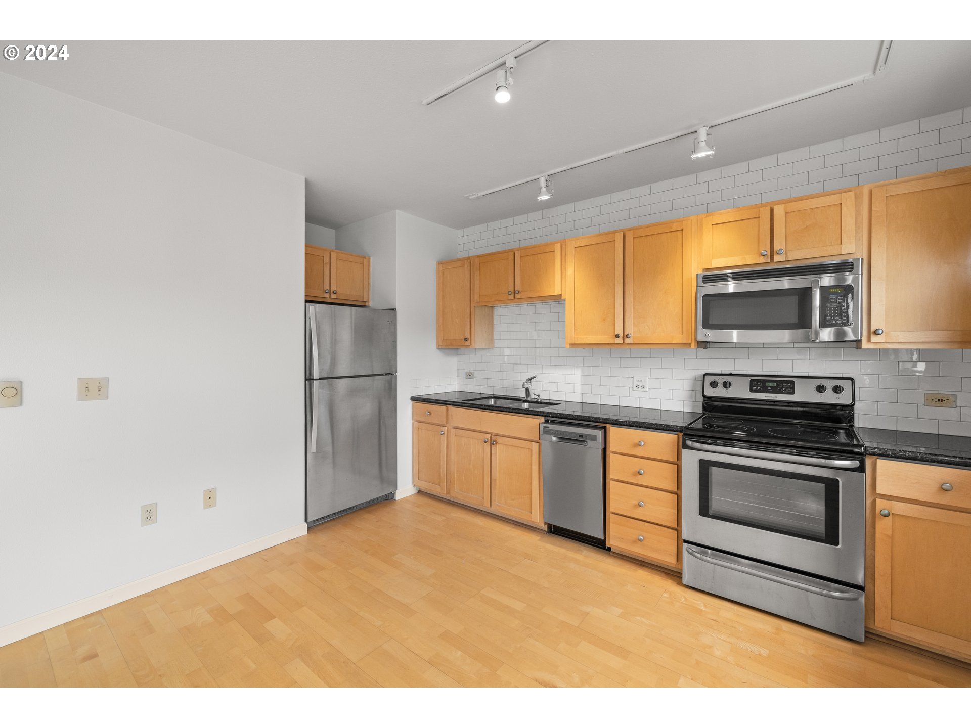 1134 Southwest Jefferson Street, Unit 508 Portland, OR 97201 - Photo 7 of 29 a kitchen with stainless steel appliances granite countertop a stove a sink and a refrigerator