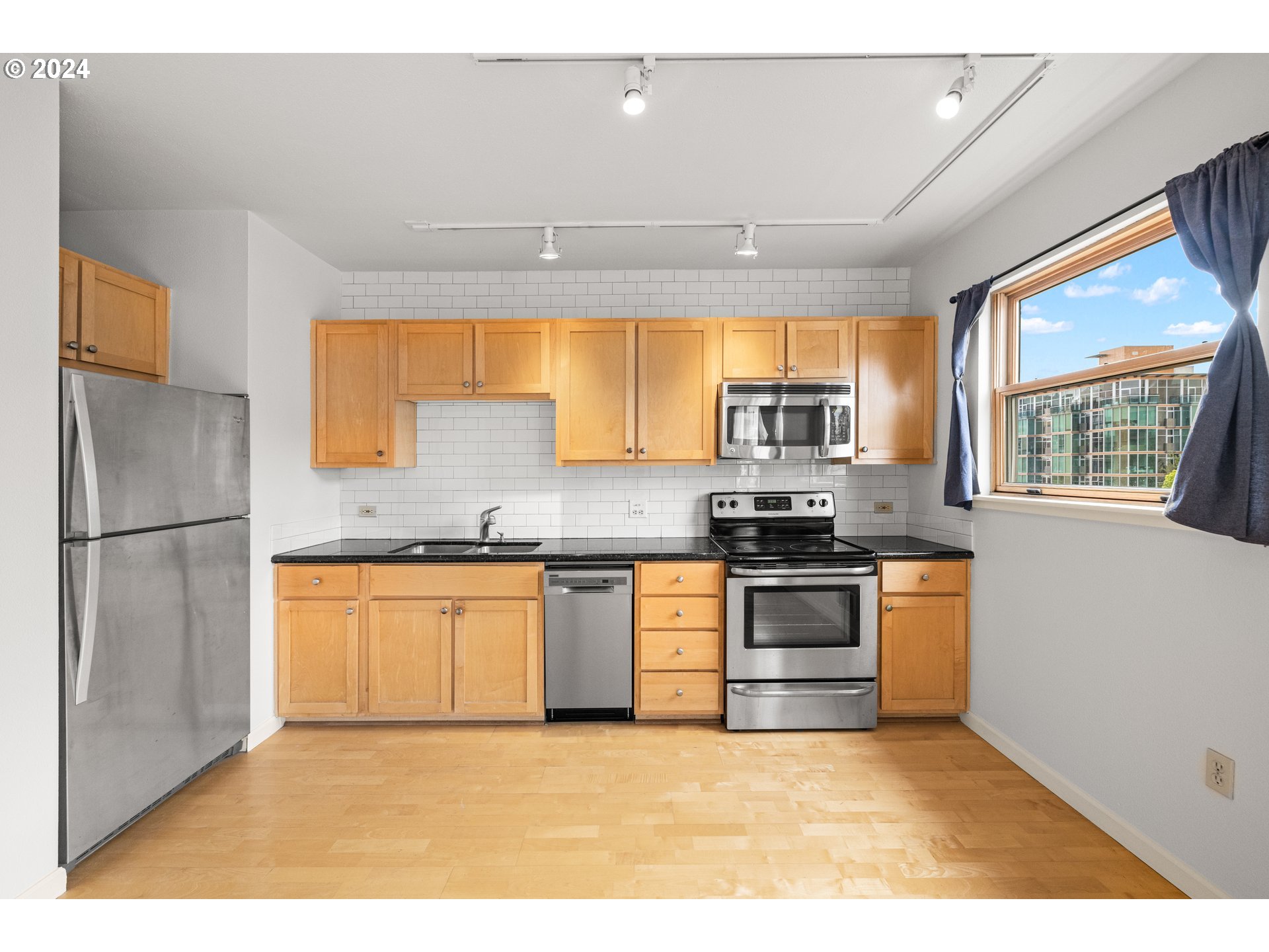 1134 Southwest Jefferson Street, Unit 508 Portland, OR 97201 - Photo 8 of 29 a kitchen with stainless steel appliances granite countertop a stove a sink and a refrigerator