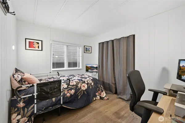 a bedroom with a bed and wooden floor