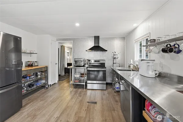 a kitchen with stainless steel appliances a stove a sink and a refrigerator