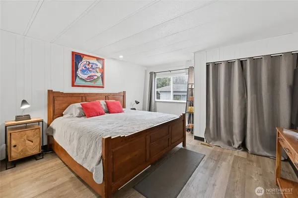 a bedroom with a bed and wooden floor