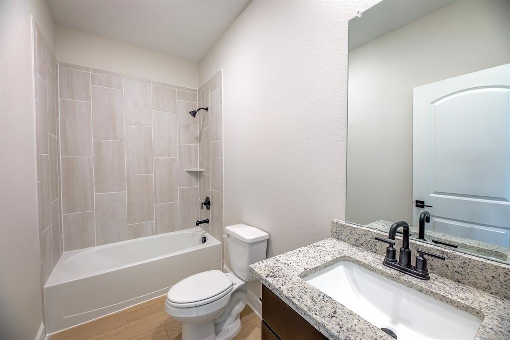1330 Windemere Way Princeton, TX 75407 - Photo 20 of 25 a bathroom with a granite countertop sink toilet and shower