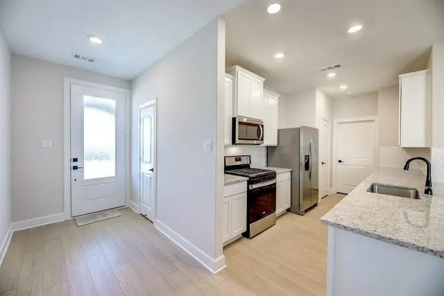 a kitchen with stainless steel appliances granite countertop a sink stove and refrigerator