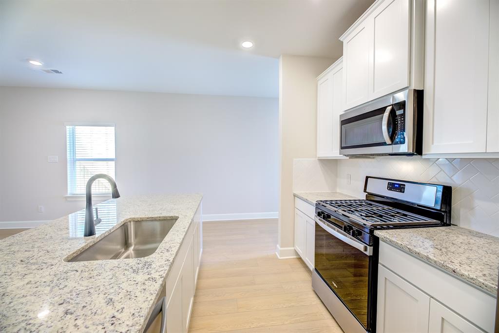 1330 Windemere Way Princeton, TX 75407 - Photo 9 of 25 a kitchen with granite countertop a sink and a stove top oven