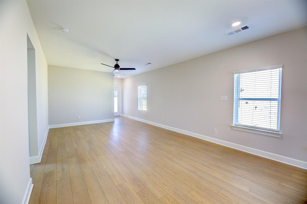 1330 Windemere Way Princeton, TX 75407 - Photo 10 of 25 an empty room with wooden floor and windows