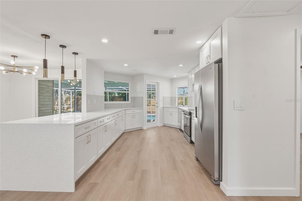1330 Horizon Road Venice, FL 34293 - Photo 13 of 40 a large white kitchen with a refrigerator a sink dishwasher and a stove with wooden floor