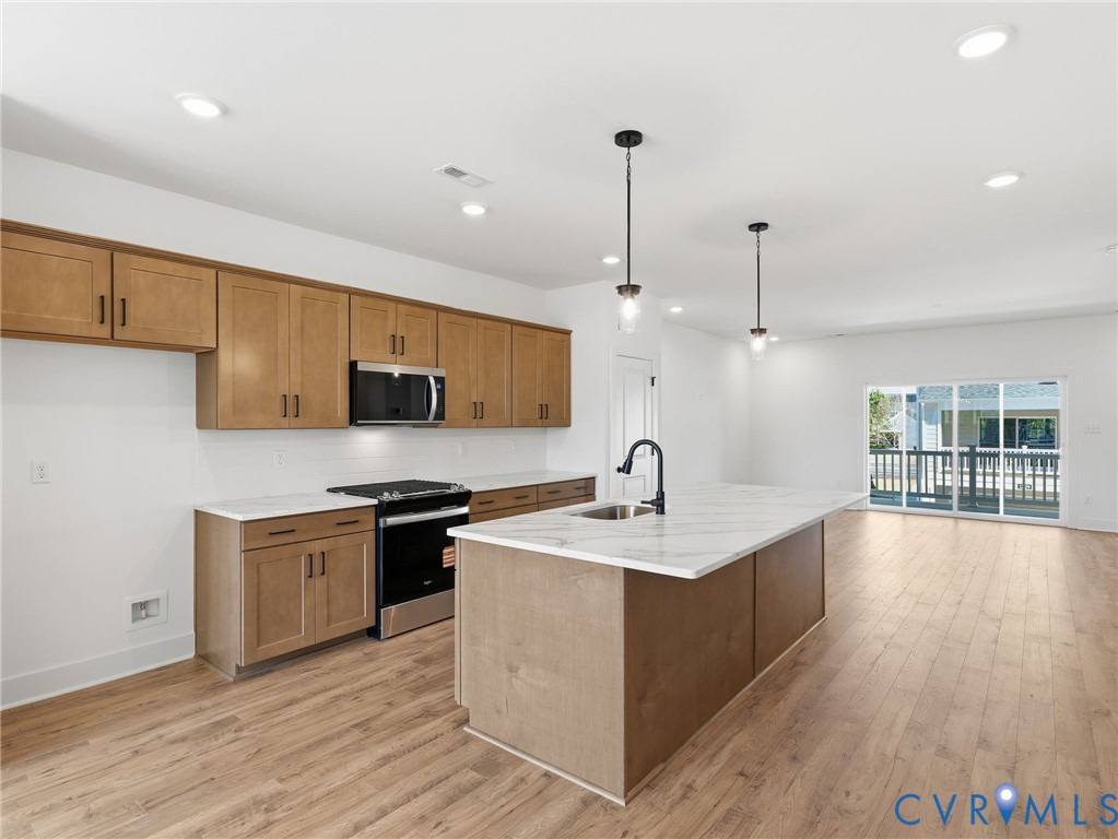 12026 Flowering Lavender Loop Henrico, VA 23233 - Photo 3 of 42 a kitchen with stainless steel appliances granite countertop a sink a stove and a wooden floors