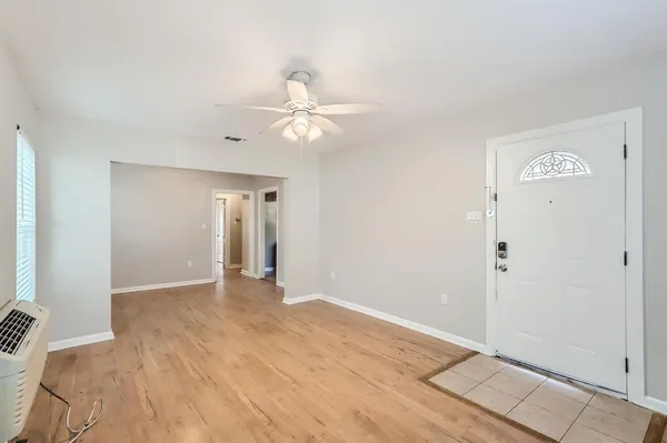 a view of an empty room with closet and a window