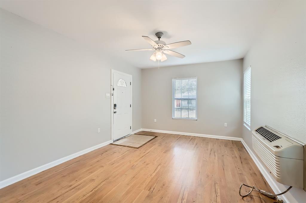 224 East Boyd Street Bonham, TX 75418 - Photo 4 of 28 an empty room with wooden floor fan and windows