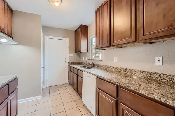 a kitchen with granite countertop a sink stove and cabinets