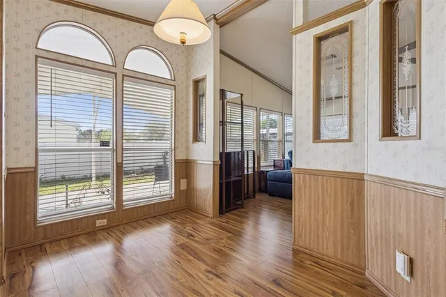 a view of a hallway with wooden floor and windows