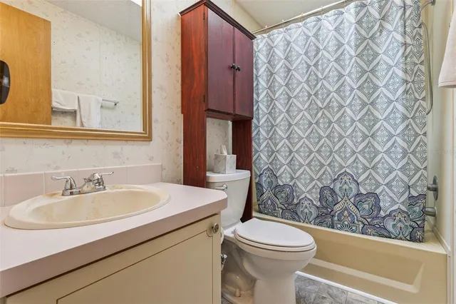 a bathroom with a sink a toilet and shower curtain